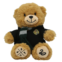 A plush toy depicting a brown teddy bear with a green-and-grey scarf and a Hogwarts robe, featuring exclusive silkscreen details on its paws.