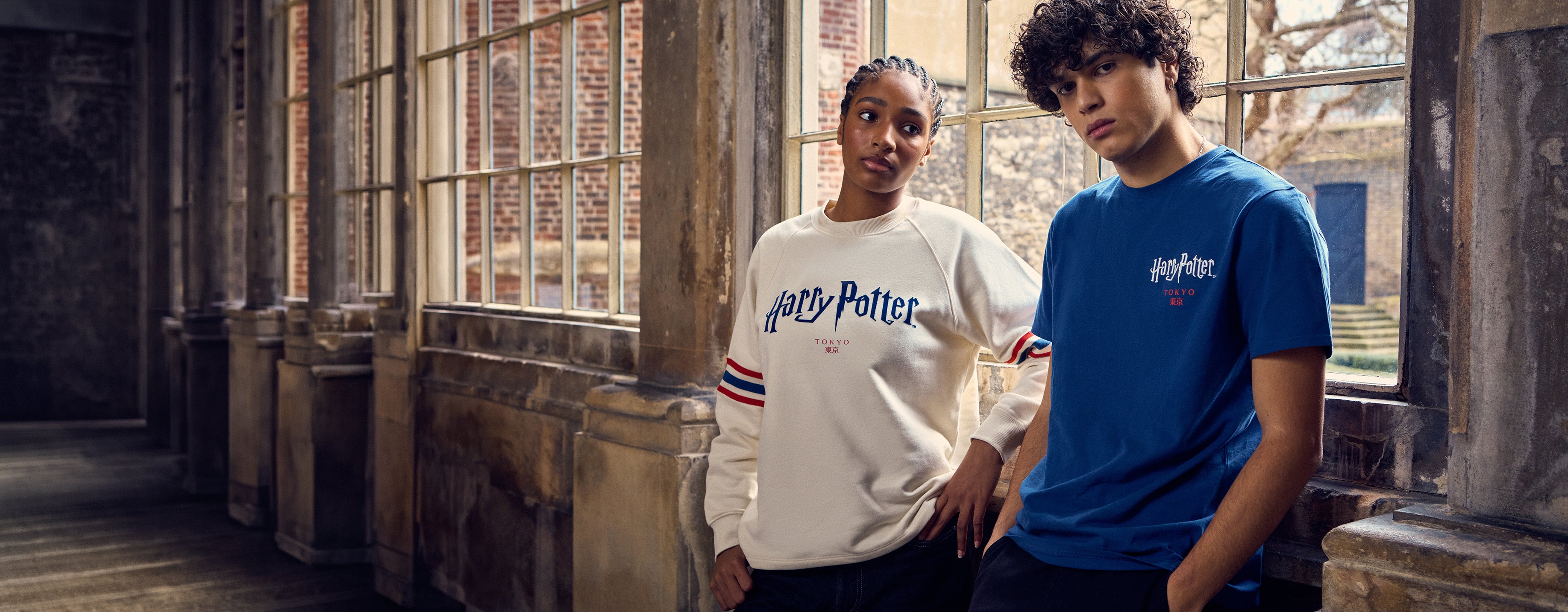 Two people wearing Harry Potter-themed clothing in a rustic indoor setting.